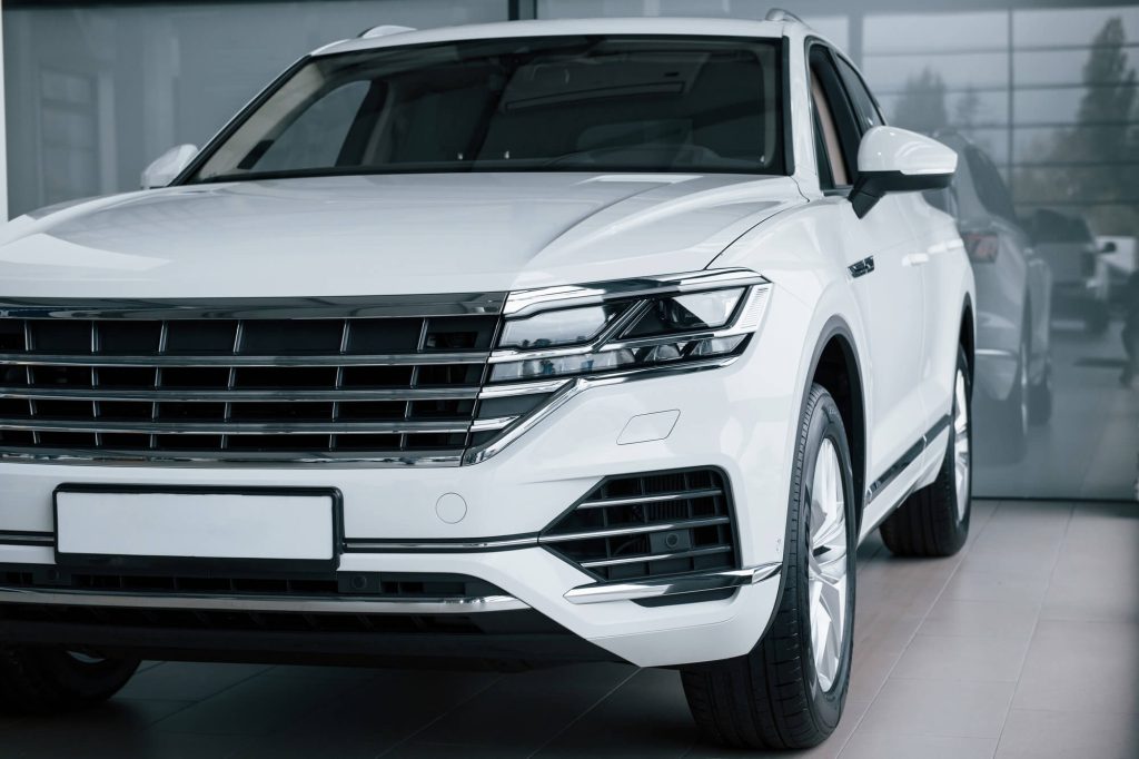 grey glass behind particle view of modern luxury white car parked indoors at daytime.jpg